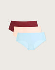 Three pairs of seamless underwear in burgundy, beige, and blue on a light gray background