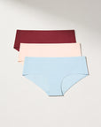 Pack of seamless underwear in burgundy, tan and blue on a light gray background