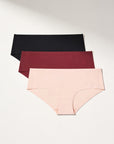 Three pairs of seamless women's underwear in black, burgundy, and beige on a light gray background.