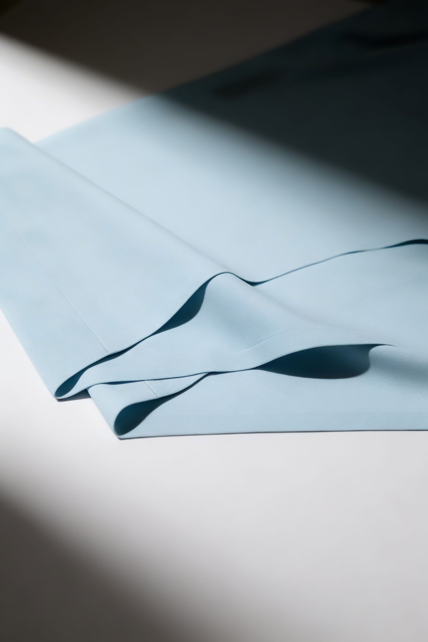 Light blue high quality recycled nylon fabric with a wavy pattern on a white surface